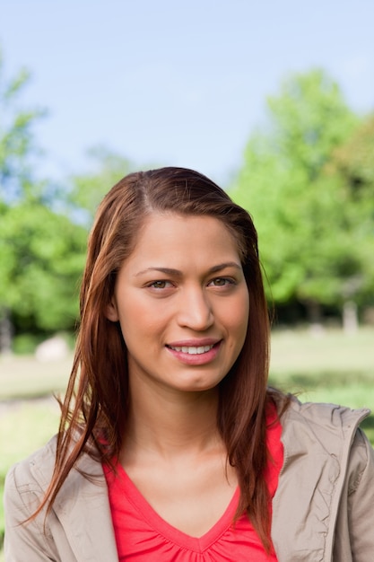 Mulher, sorrindo, como, ela, olha direto, frente, dela, em, um, parque