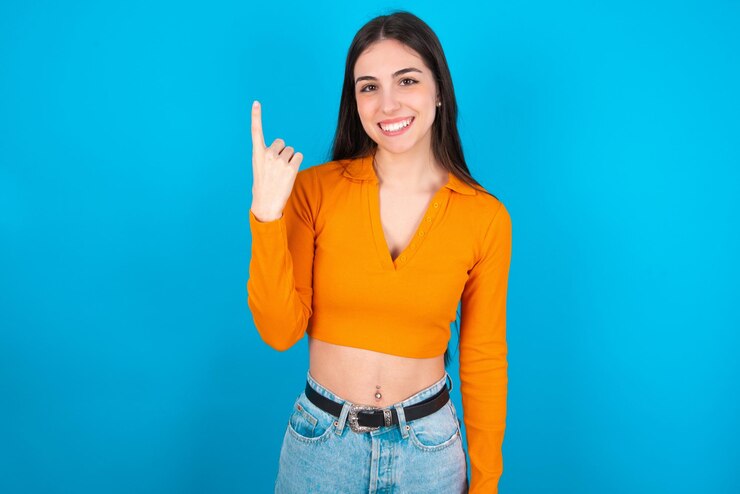 Foto mulher sorrindo e parecendo amigável mostrando o número um ou primeiro com a mão em contagem regressiva