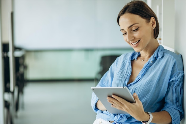 Mulher sorrindo e usando tablet no escritório