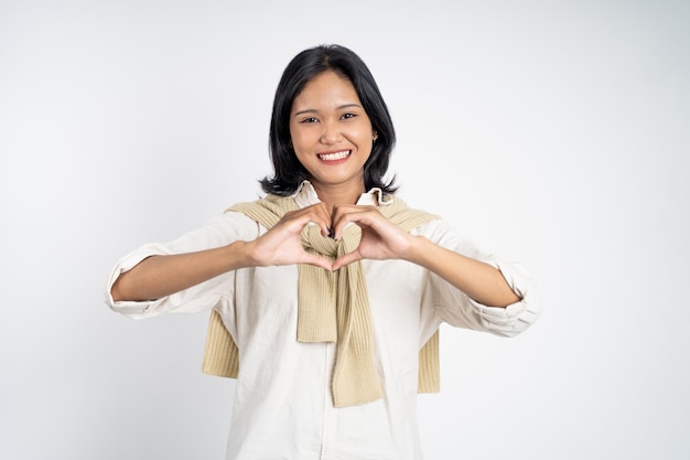 Mulher sorrindo em forma de coração com os dedos isolados