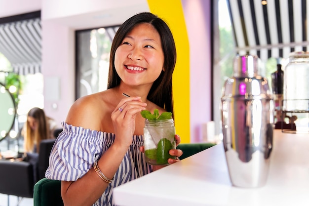 Mulher sorrindo feliz bebendo um refrigerante