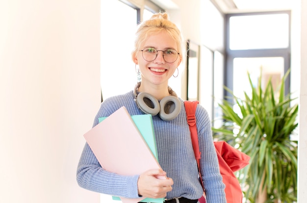 mulher sorrindo feliz com uma mão no quadril e atitude confiante, positiva, orgulhosa e amigável