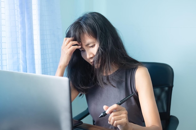 Mulher sozinha estressa e usa laptop de computador trabalhando no escritório com nervosismo porque tecnologia de trabalho problemático para negócios ou conceito de finanças
