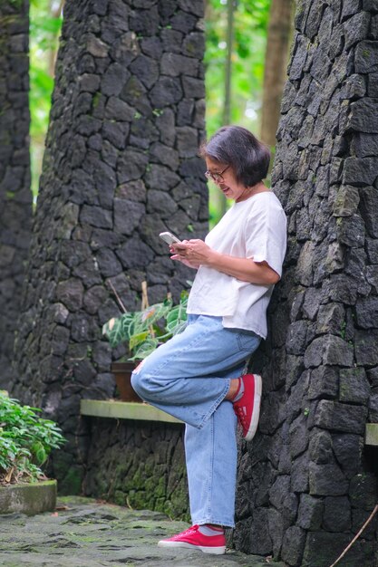 Mulher sozinha no jardim fazendo ligação privada