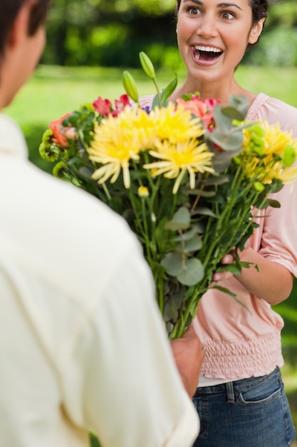 Mulher surpreendida quando ela é apresentada com flores por sua amiga