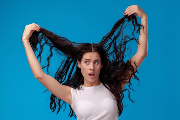 Mulher surpresa está puxando o cabelo dela e desviando o olhar