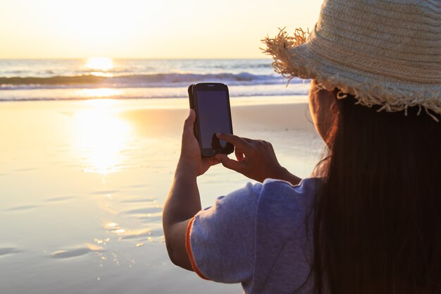 Mulher tailandesa usando smartphone na praia