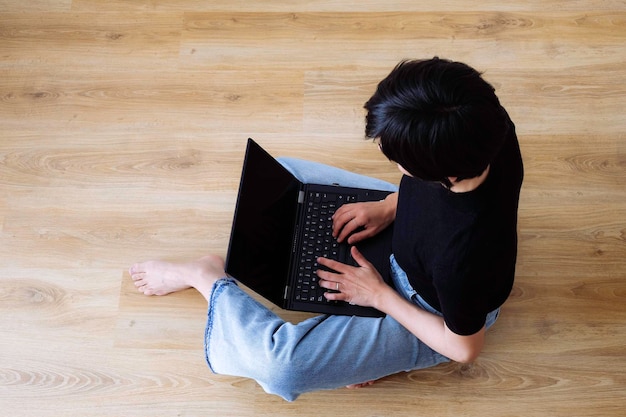 Mulher teletrabalhando com laptop no chão em casa