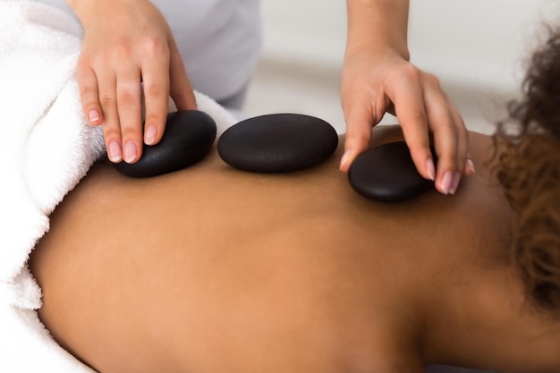 Mulher tendo massagem com pedras quentes nas costas