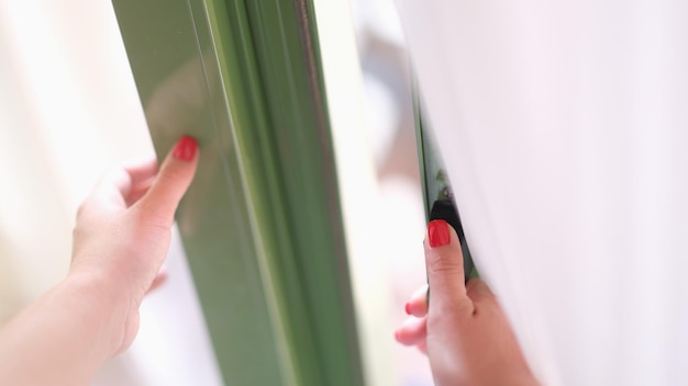 Mulher tenta abrir a porta segurando a janela ou a maçaneta da porta. Segurança e portas de varanda de vidro