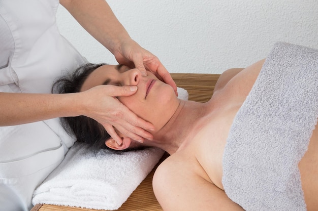 Mulher terapeuta fazendo massagem na cabeça de uma mulher