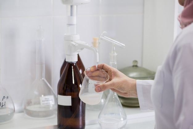 Mulher testando amostras de produtos lácteos no laboratório. laboratório de teste de uma fábrica de leite