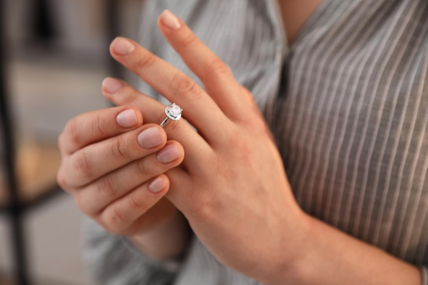 Mulher tirando a aliança de casamento dentro de casa closeup Conceito de divórcio