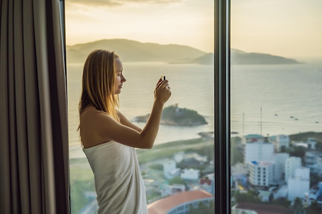 Mulher tirando foto da cidade na luz da manhã