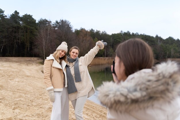 Foto mulher tirando foto de seus amigos com a câmera enquanto viaja