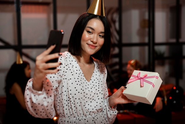 Foto mulher tirando uma selfie com um presente