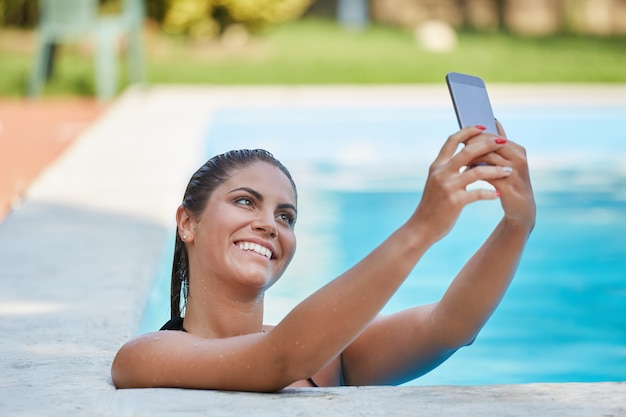 Mulher tirar uma selfie na piscina