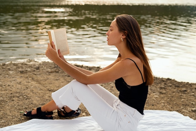 Foto mulher tiro cheio, lendo ao ar livre