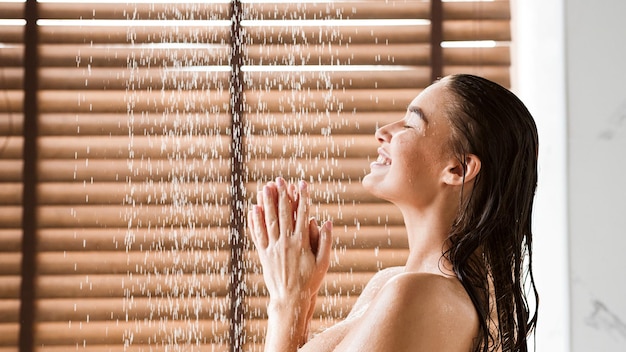 Foto mulher tomando banho desfrutando de água espirrando nela