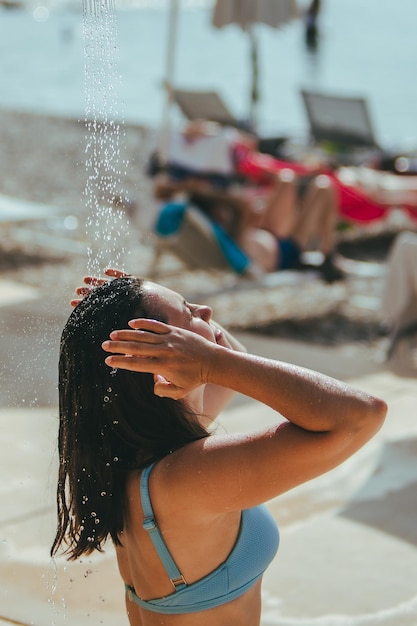 Foto mulher tomando banho na praia do mar lava a água salgada
