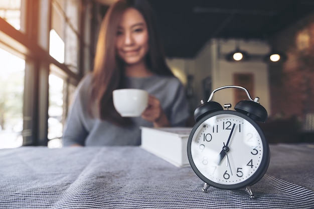 Foto mulher tomando café com despertador