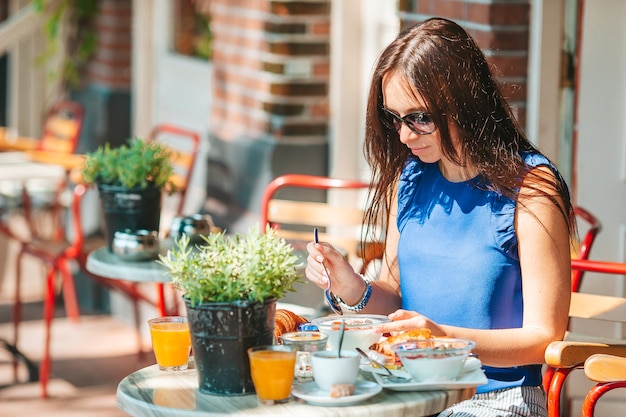 Mulher tomando café da manhã ao ar livre