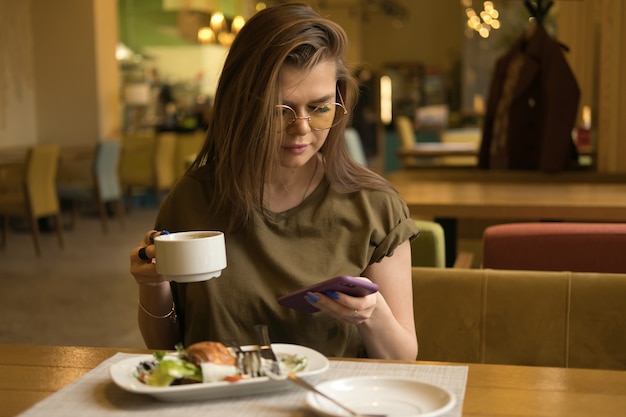 Mulher tomando café da manhã em um café