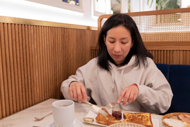 Mulher tomando café da manhã em um restaurante