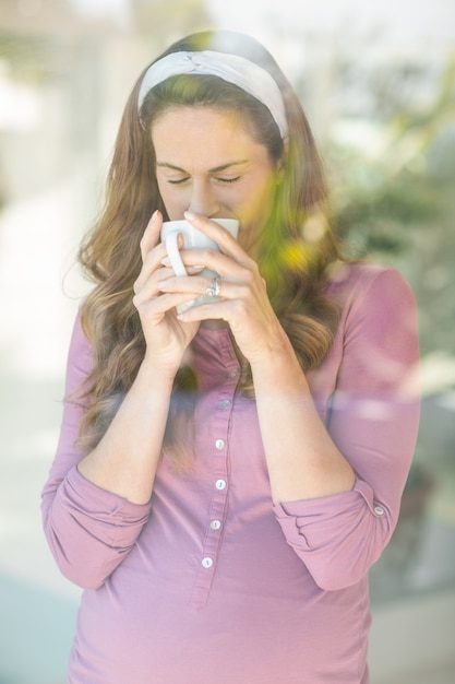 Mulher tomando café da xícara