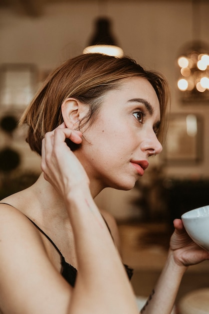 Mulher tomando café na sala de estar