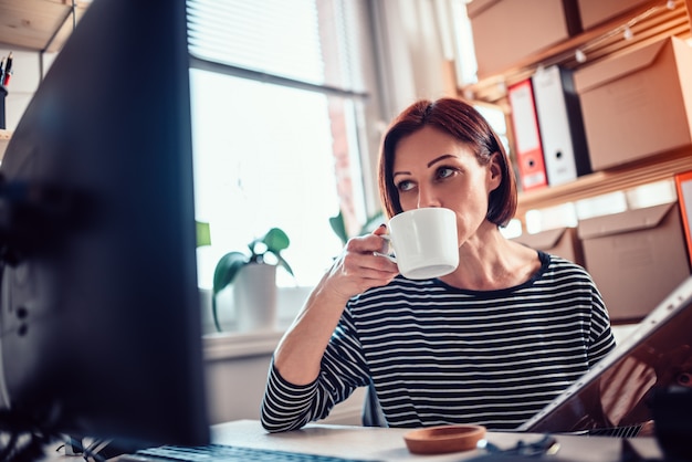 Mulher tomando café no escritório