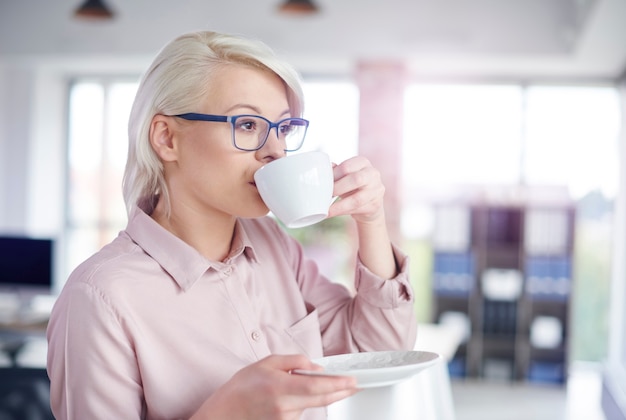 Mulher tomando café no escritório