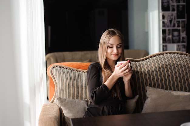 Mulher tomando café pela manhã em um restaurante