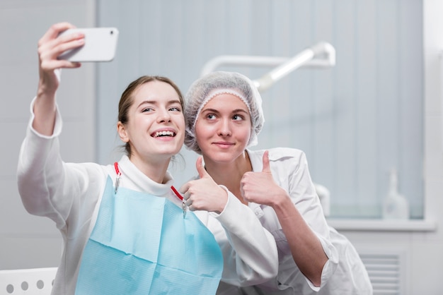 Foto mulher tomando uma selfie com dentista