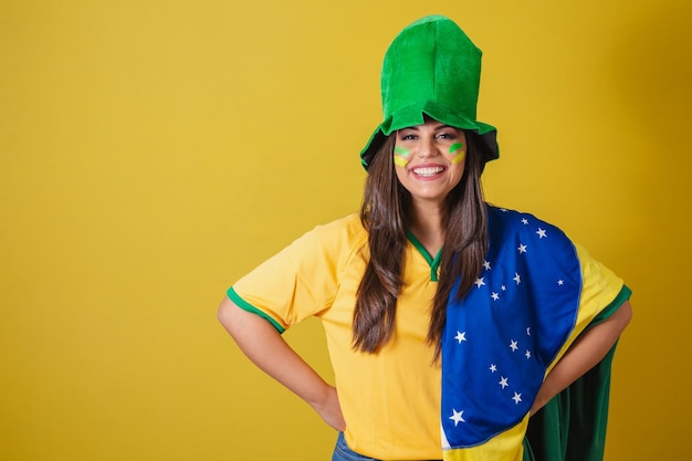 Mulher torcedora da Copa do Mundo Brasil 2022 vestindo roupa típica de fã para ir ao jogo bandeira brasileira e chapéu verde