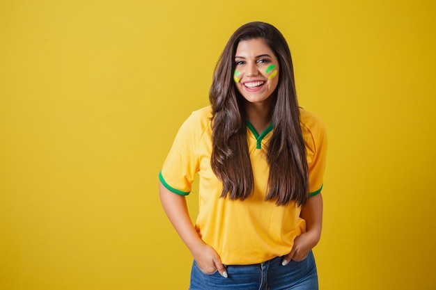 Mulher torcedora do campeonato de futebol da copa do mundo 2022 do Brasil mãos nos bolsos sorrindo