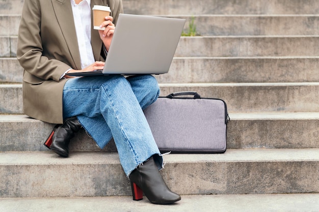 Mulher trabalha ao ar livre com seu laptop