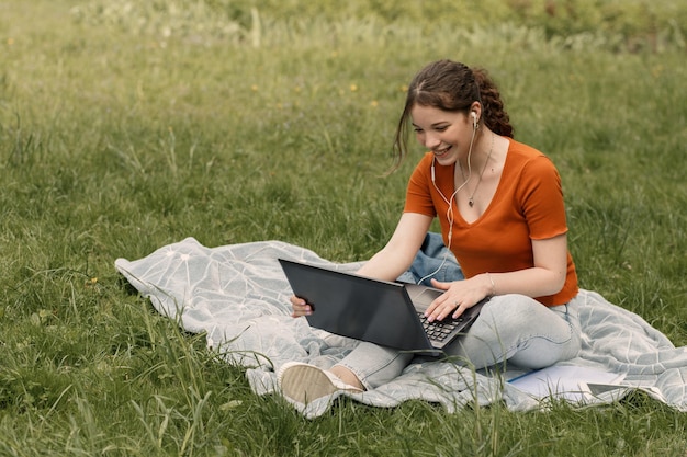 Mulher trabalha com laptop no parque