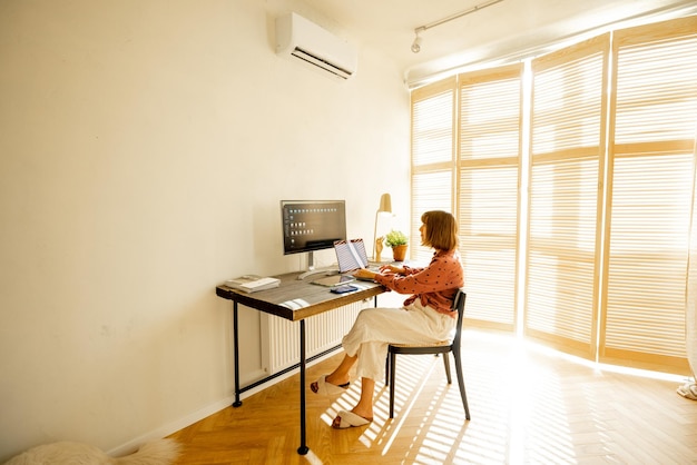 Mulher trabalha online em computadores em casa