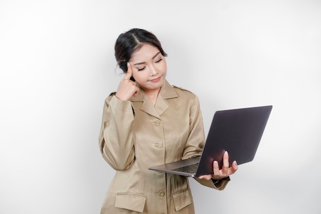 Mulher trabalhadora do governo atenciosa segurando seu laptop e se perguntando sobre seu trabalho PNS vestindo uniforme khaki