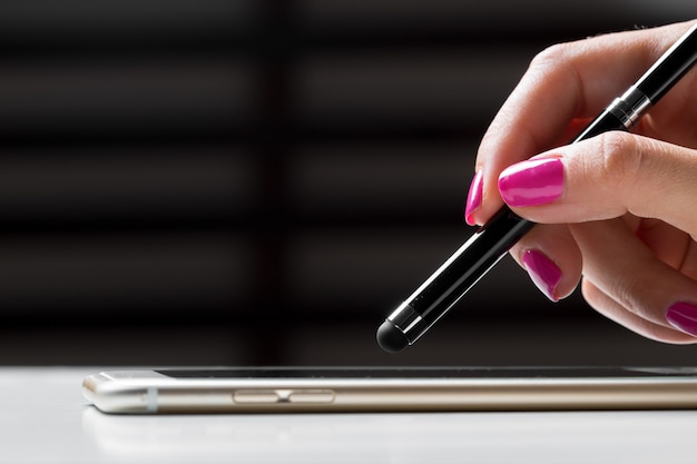 Mulher trabalhando com caneta em um celular inteligente