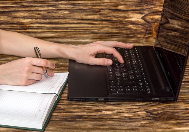 Foto mulher trabalhando com laptop e bloco de notas