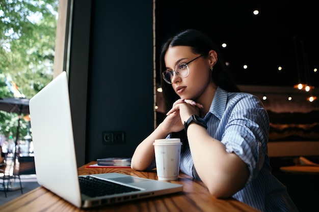 Mulher trabalhando com laptop no café