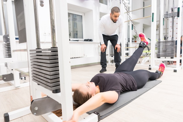 Mulher trabalhando com personal trainer na academia