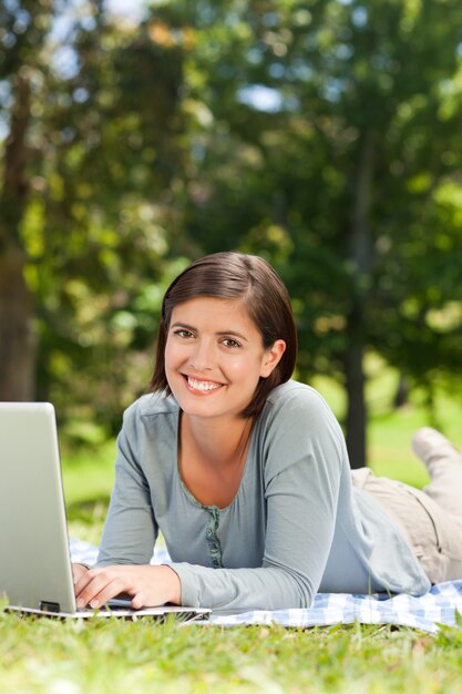 Mulher trabalhando em seu laptop no parque