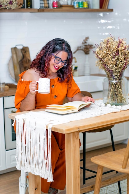 Mulher trabalhando em seu livro desfrutando de uma xícara de café