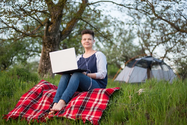 Mulher trabalhando em um laptop ao ar livre