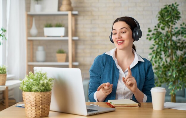 Mulher trabalhando em um laptop em casa.