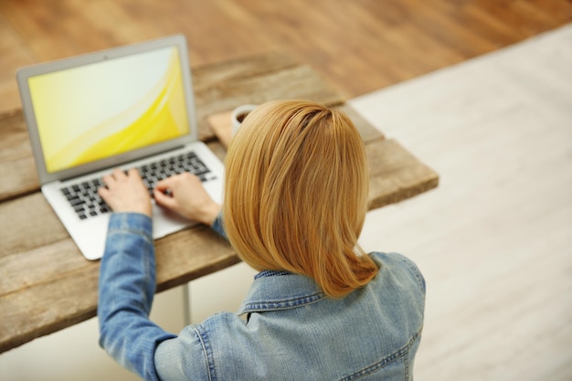 Mulher trabalhando em um laptop na mesa de escritório