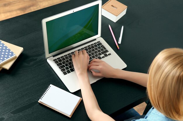 Mulher trabalhando em um laptop na mesa de escritório